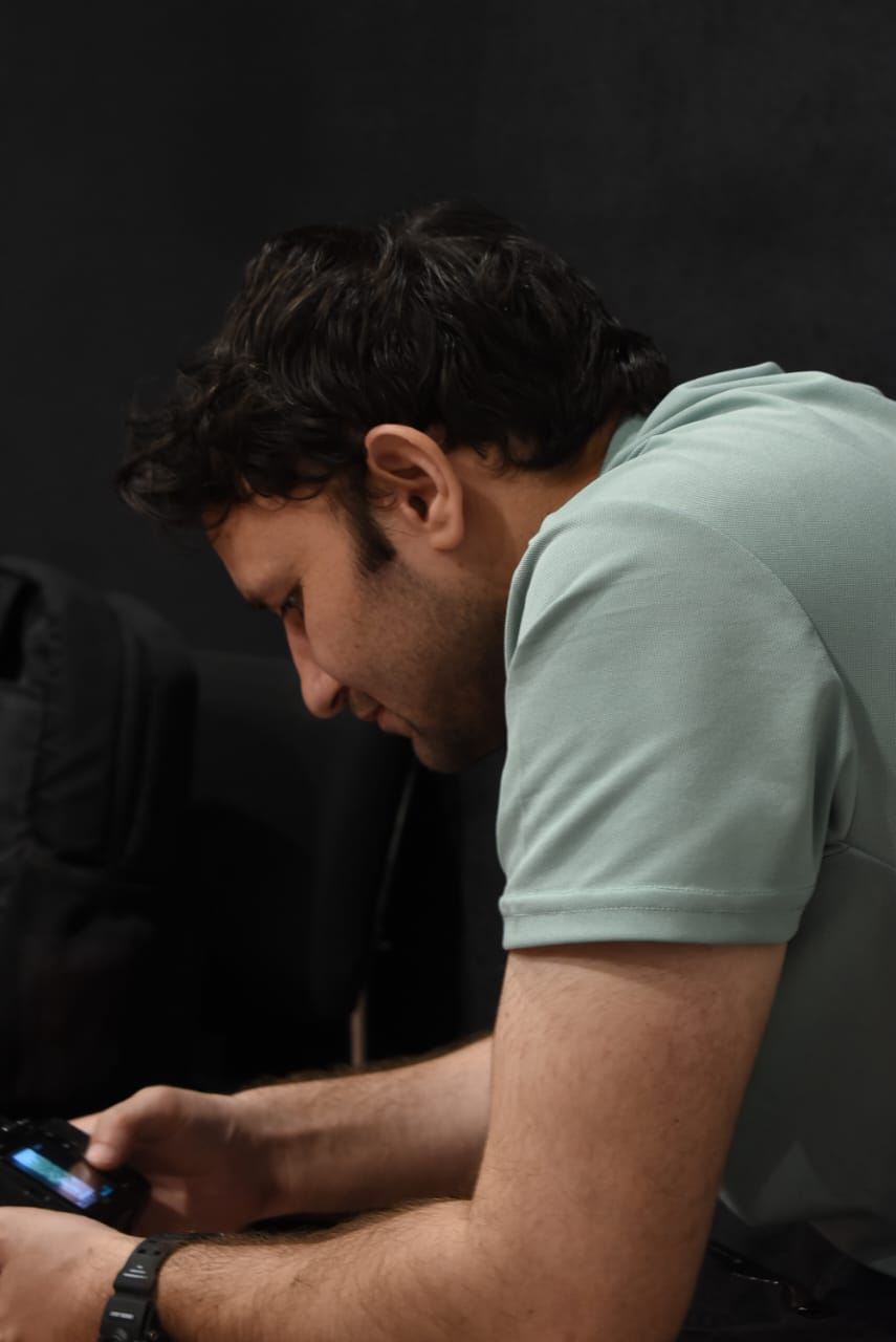 Ahmed Qureshi looking down while holding a camera